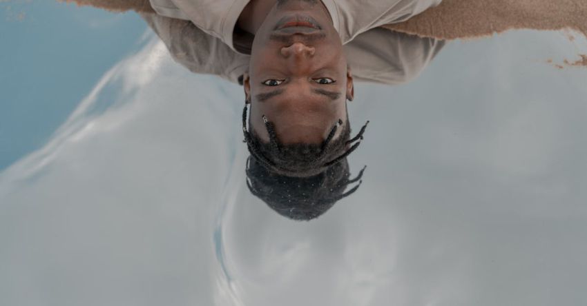 Water Features - High Angle Portrait of Man Laying in Water Reflecting Sky